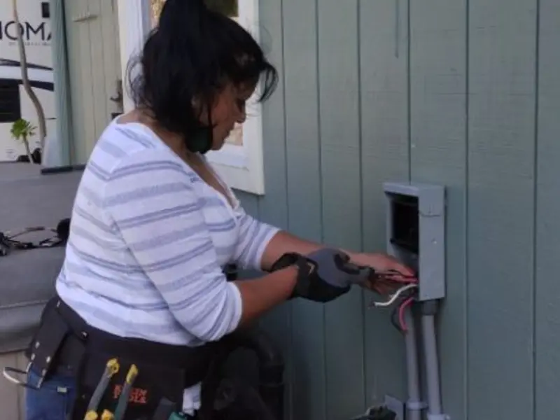 Licensed electrician wiring an exterior subpanel in Navy